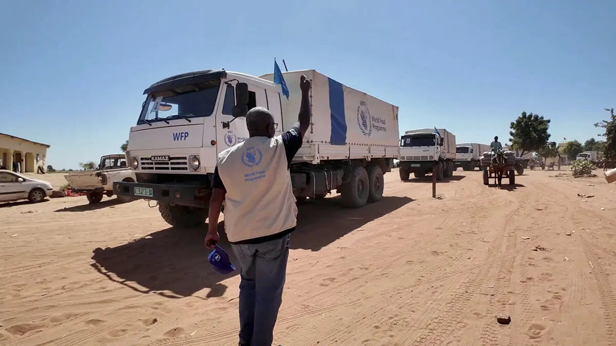Un miembro del personal señala los camiones del Programa Mundial de Alimentos (PMA) que transportan alimentos y suministros nutricionales desde Chad al campamento de Zamzam en Darfur, Sudán, en Adre, Chad - PMA vía REUTERS