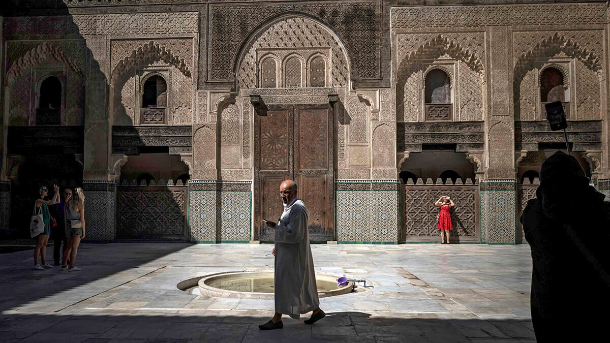 AFP/FADEL SENNA - Visitantes recorren la Madrasa Bou Inania, una escuela teológica construida entre 1350 y 1355 d.C., en la antigua ciudad marroquí de Fez