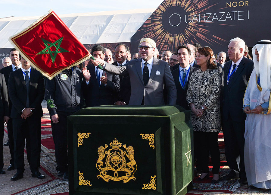 En esta foto de archivo tomada el 4 de febrero de 2016, el rey marroquí Mohammed VI (centro) ondea la bandera marroquí mientras inaugura la planta de energía solar concentrada (CSP) Noor 1, a unos 20 kilómetros (12,5 millas) de la ciudad de Ouarzazate - AFP/FADEL SENNA