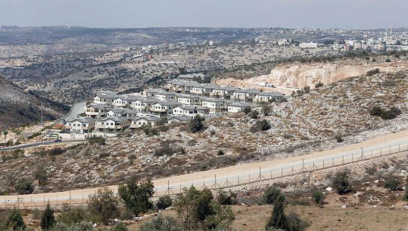 Vista parcial del asentamiento israelí de Elkana (en primer plano) frente a la aldea de Saniriya, en el noroeste de Cisjordania (al fondo)