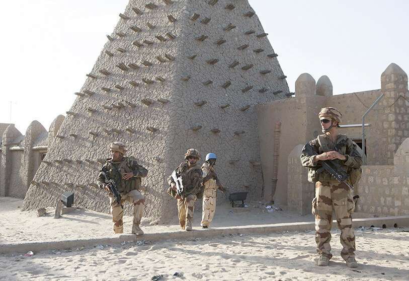 Soldados franceses y personal de mantenimiento de la paz de las Naciones Unidas de Burkina Faso patrullan frente a la mezquita de Sankore, en Timbuktu, el 5 de noviembre de 2014.