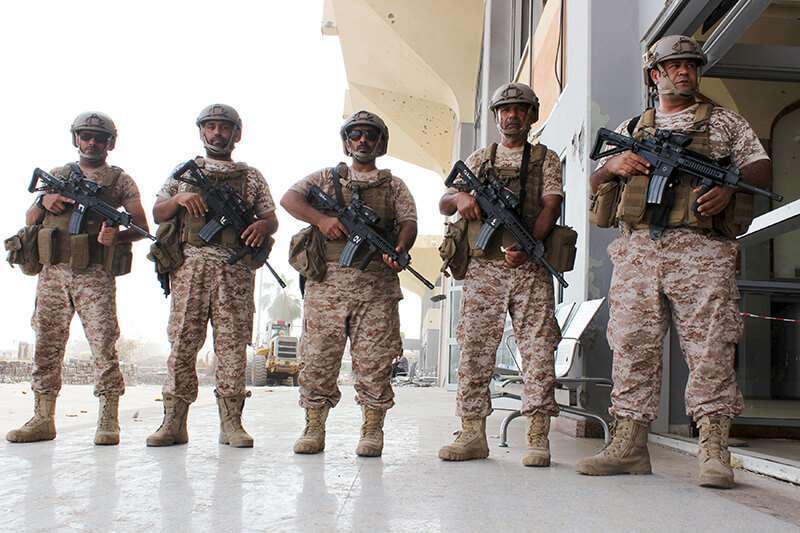 Soldados de Emiratos Árabes Unidos hacen guardia mientras se descargan equipos militares de un avión militar de los EAU en el aeropuerto de Adén, ciudad portuaria del sur de Yemen, el 12 de agosto de 2015