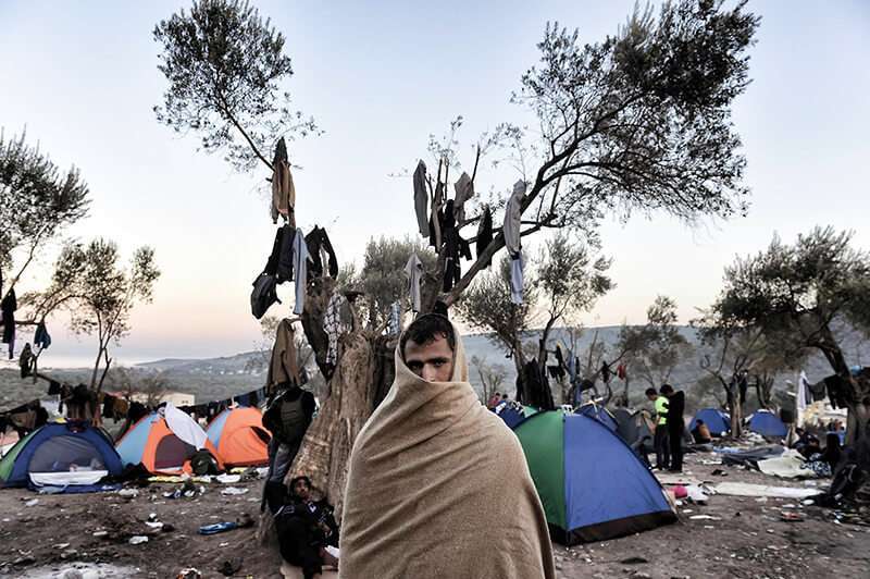 Un hombre cerca de las tiendas de campaña donde viven refugiados e inmigrantes en un campo en las afueras del centro de registro de Moria, en la isla griega de Lesbos