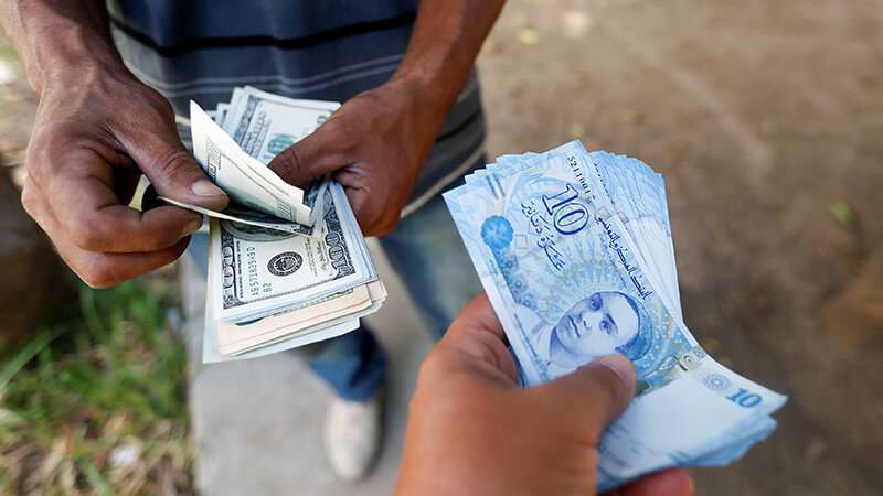 Un hombre compra dólares a un cambista en el mercado negro de la capital, Túnez