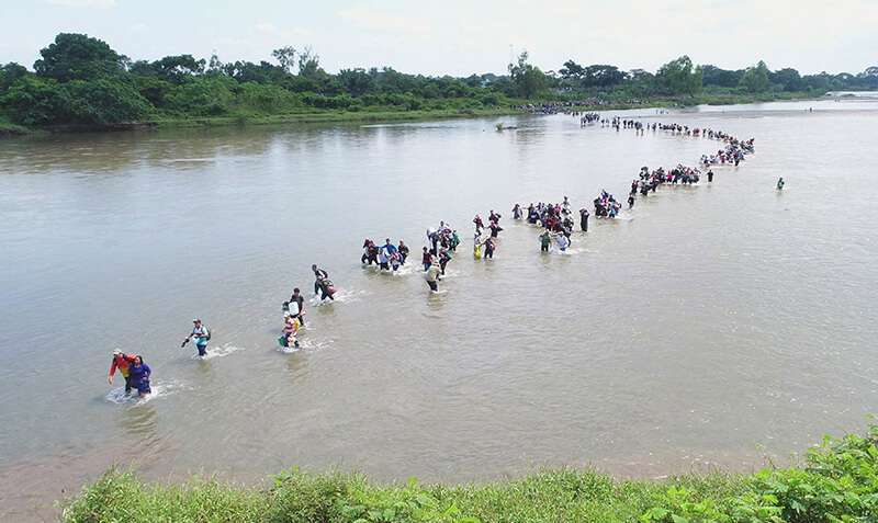 Migrantes de El Salvador que viajan en una caravana cruzan el río Suchiate, la frontera entre Guatemala y México