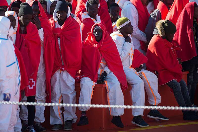 Migrantes esperan en el puerto de Málaga el 9 de enero de 2019 después de que un bote inflable que transportaba a 188 migrantes fuera rescatado por los guardacostas españoles
