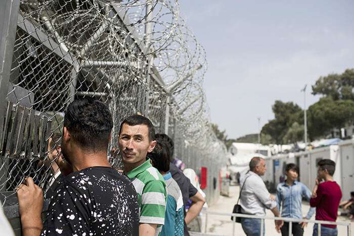 Migrantes y refugiados esperan frente a las oficinas del Servicio Europeo de Apoyo al Asilo en el campo de Moria, en la isla de Lesbos, al noreste del mar Egeo, Grecia.