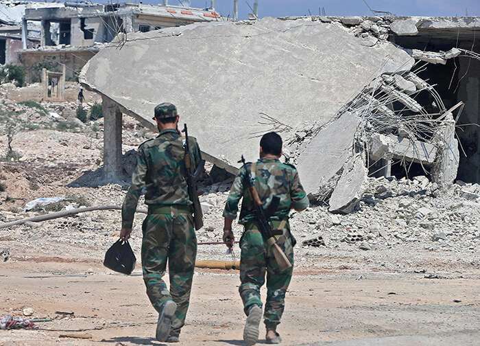 Fuerzas del Gobierno sirio se reúnen cerca de la ciudad de Khan Sheikhoun en el campo sur de la provincia rebelde de Idlib el 18 de agosto de 2019.