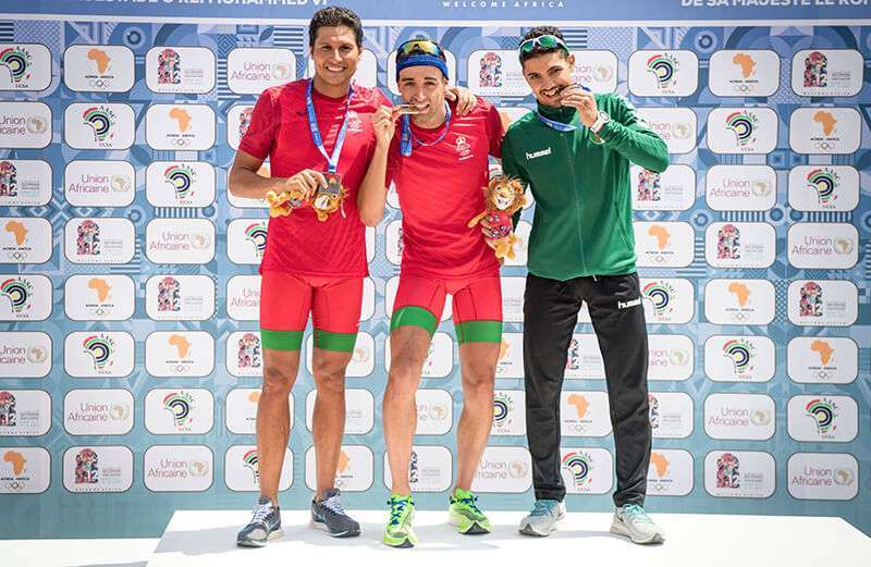 Mohammed El Mehdi Essadiq, de Marruecos, Badr Siwane de Marruecos, Oussama Hella, de Argelia, posan en el podio de la final masculina de triatlón con sus medallas de plata, oro y bronce respectivamente, durante la 12ª edición de los Juegos Africanos, el 24 de agosto de 2019 en Rabat