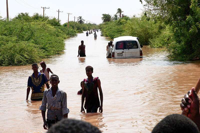 Sudaneses caminan por una carretera inundada a 50 km al norte de Kharoum, el 26 de agosto de 2019