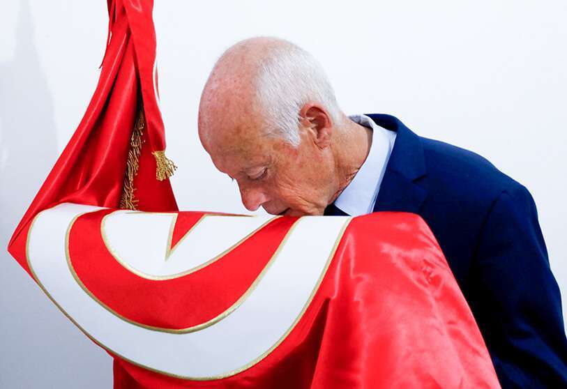 El candidato presidencial Kais Saied besa una bandera tunecina tras los resultados no oficiales de las elecciones presidenciales de Túnez