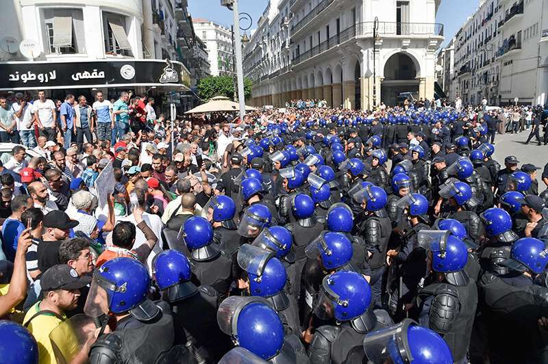 Manifestantes argelinos se enfrentan a policías antidisturbios durante una protesta cerca del edificio del Parlamento en Argel el 13 de octubre de 2019