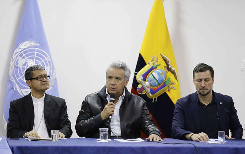 El presidente ecuatoriano Lenín Moreno habla durante las negociaciones con los manifestantes antigubernamentales en Quito, Ecuador, el domingo 13 de octubre de 2019. A la derecha, Arnaud Peral, de las Naciones Unidas, y a la izquierda, el arzobispo Luis Gerardo Cabrera Herrera, vicepresidente de la Conferencia Episcopal de Ecuador