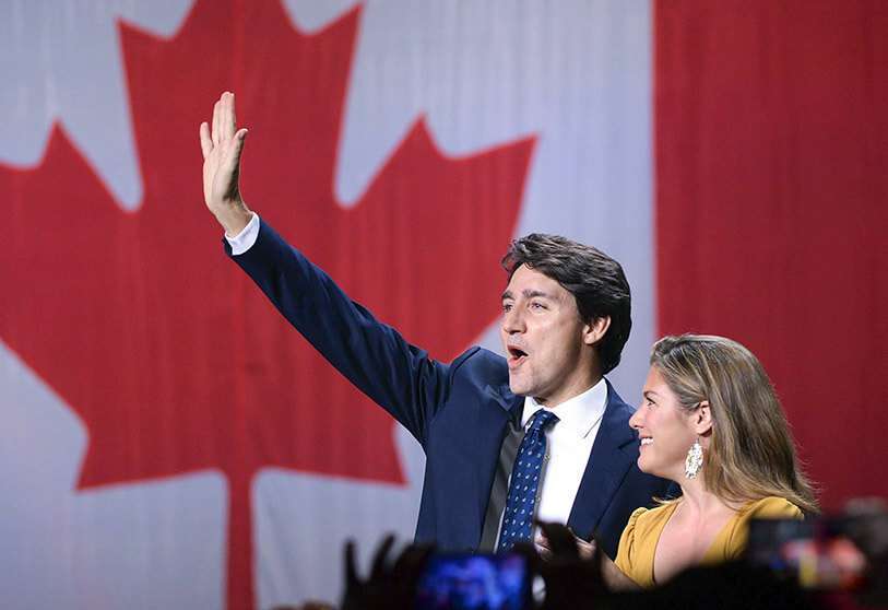 El líder liberal Justin Trudeau y su esposa Sophie Gregoire Trudeau saludan en el escenario de las elecciones liberales en Montreal, el lunes 21 de octubre de 2019.