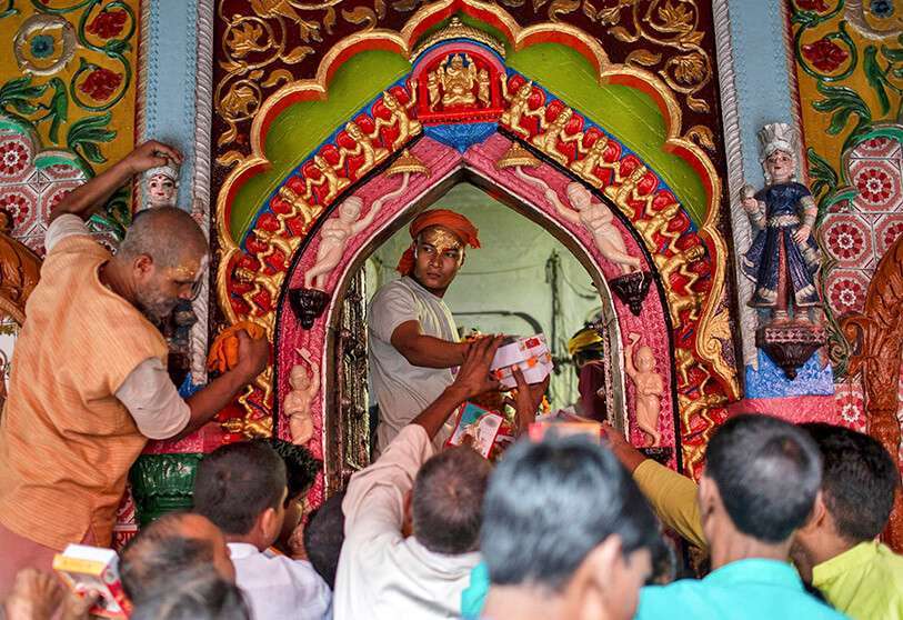 Un sacerdote hindú distribuye dulces como "Prasad" (ofrendas sagradas) después de una sesión de oración dentro de un templo en Ayodhya, el 22 de octubre de 2019