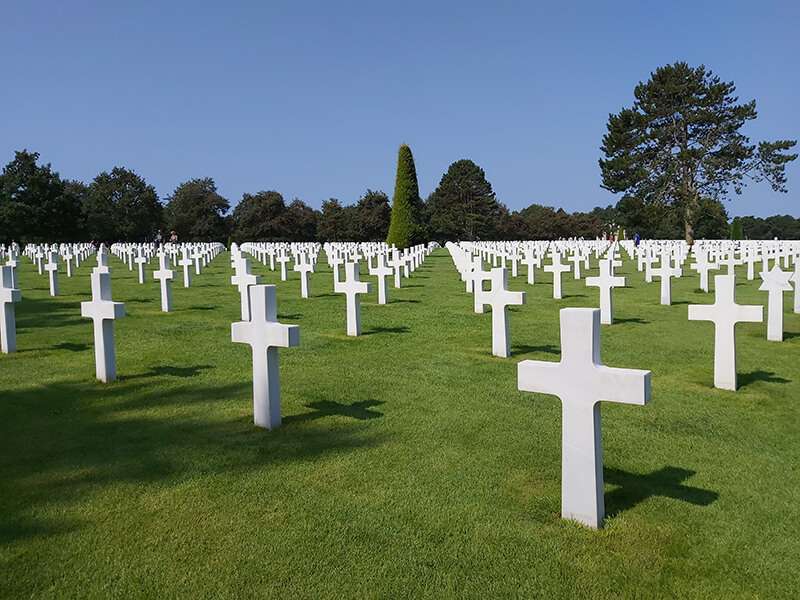 las lápidas del cementerio americano están perfectamente alineadas. Entre las cruces, se asoma alguna estrella de David. En medio, se alza un ciprés