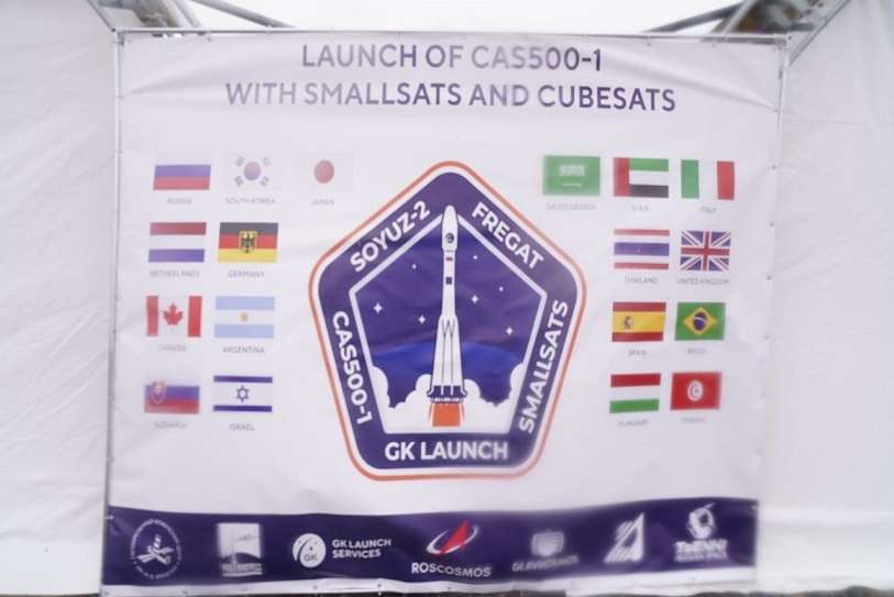 Imagen del Photo Call donde figuran las banderas de los 17 países que envían satélites al espacio, entre ellos España. La de abajo recoge la imagen del secretario de Políticas Digitales del Gobierno de Cataluña, David Ferrer, ocultando la bandera española. Fue enviada por Twitter a la cuenta de Jordi Puigneró, el 22 de marzo