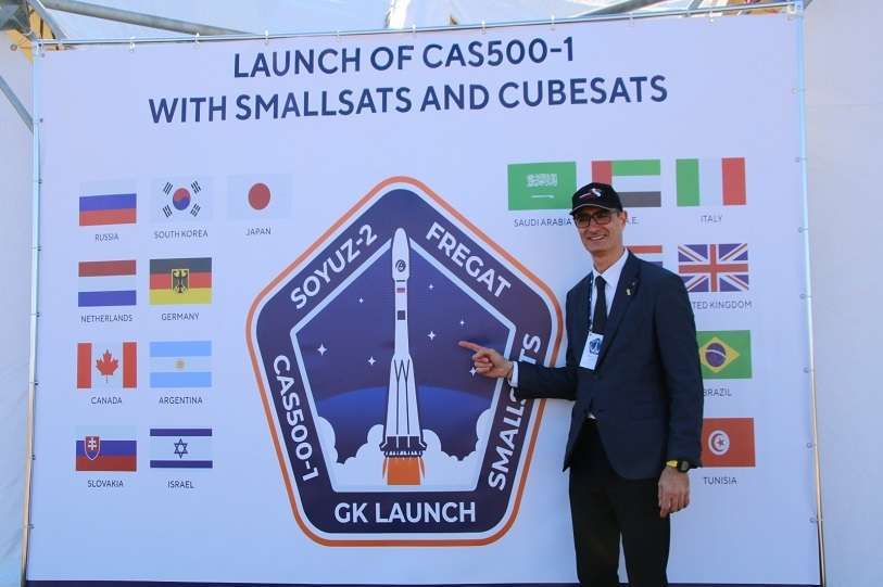 Imagen del Photo Call donde figuran las banderas de los 17 países que envían satélites al espacio, entre ellos España. La de abajo recoge la imagen del secretario de Políticas Digitales del Gobierno de Cataluña, David Ferrer, ocultando la bandera española. Fue enviada por Twitter a la cuenta de Jordi Puigneró, el 22 de marzo