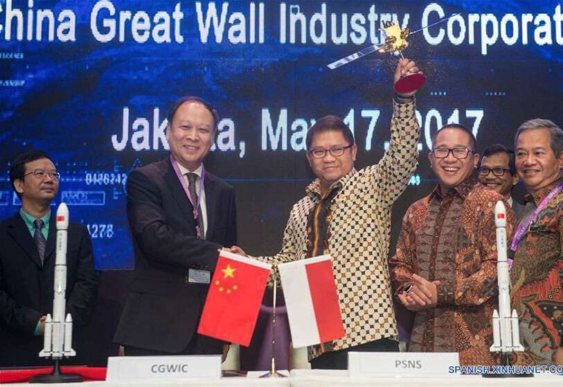 El ministro de Informática y Comunicaciones de Indonesia, Rudiantara, sostiene en alta una maqueta del Nusantara 2, mientras estrecha la mano del presidente de la Corporación Industrial Gran Muralla de China, Yin Liming, contratista principal del proyecto satelital firmado en Yakarta el 17 de mayo de 2017