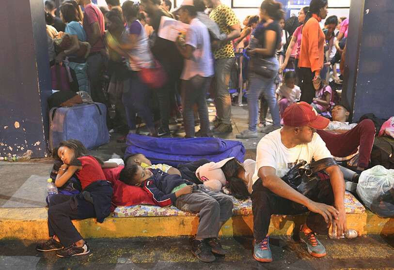 Inmigrantes hacen cola para entrar en la oficina de inmigración de Tumbes, Perú.