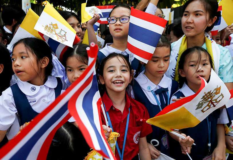 Niños ondean banderas mientras asisten a la llegada del Papa Francisco a Bangkok, Tailandia, el 20 de noviembre de 2019.