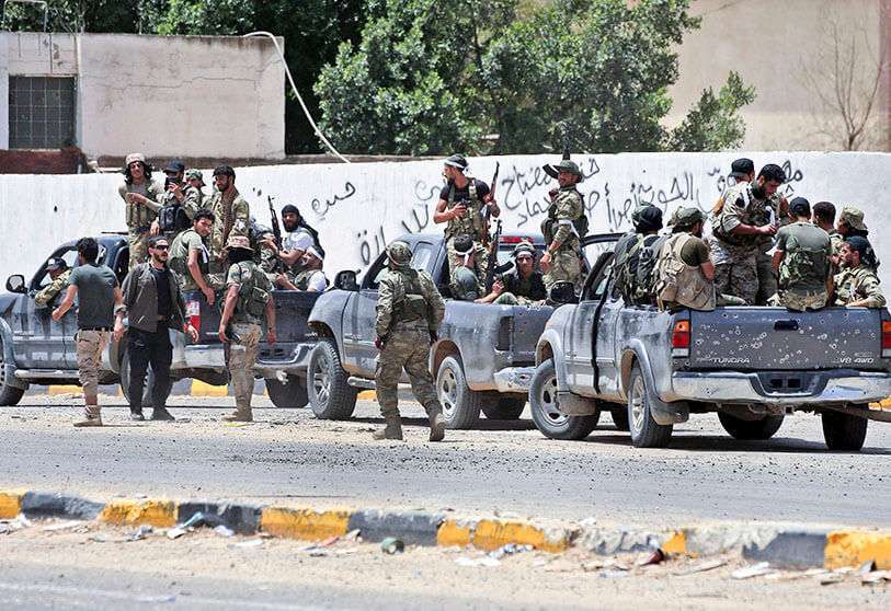 Combatientes leales al Gobierno Libio de Acuerdo Nacional (GNA) reconocido por las Naciones Unidas se desplazan en técnicos (camioneta montada con torreta) a lo largo de una carretera en el distrito de Qasr bin Ghashir, al sur de la capital libia, Trípoli, el 4 de junio de 2020