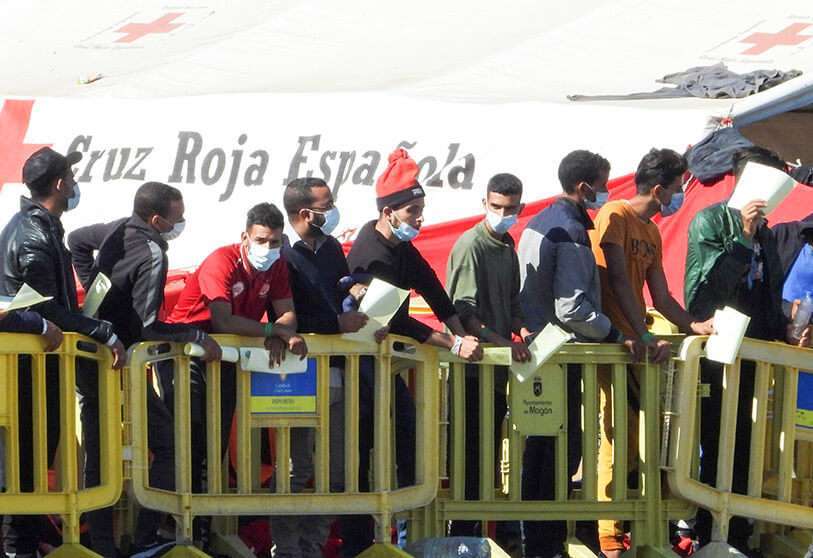 PHOTO/EUROPA PRESS - Los migrantes hacen cola en el muelle de Arguineguin, en Gran Canaria, donde más de 2.300 migrantes permanecen hacinados en el muelle en el campamento que se instaló el pasado mes de agosto en la zona portuaria