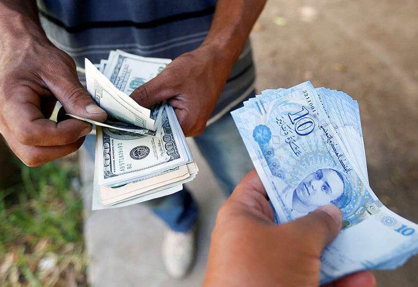 Un hombre compra dólares a un cambista en el mercado negro de la capital, Túnez