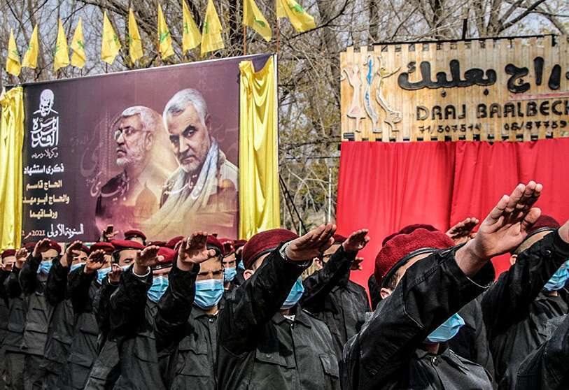 PHOTO/AFP -Miembros del movimiento Hezbolá, participan en un desfile bajo un gran cartel del comandante iraquí asesinado Abu Mahdi al-Muhandis (izq.) y del comandante de la Guardia Revolucionaria iraní Qasem Soleimani, el 2 de enero de 2021 