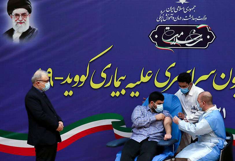 AFP/ ATTA KENARE- El hijo del ministro de Sanidad iraní, Saeed Namaki, recibe la primera vacuna contra el COVID-19