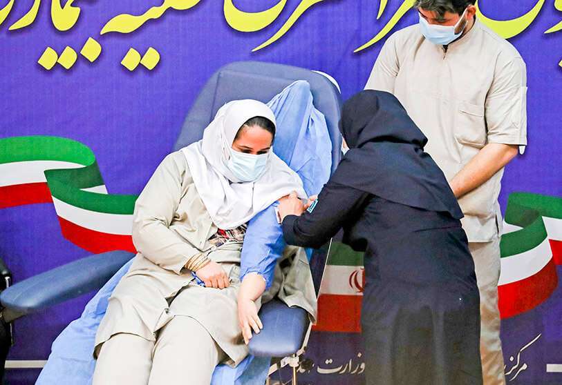AFP/ ATTA KENARE -Un sanitario iraní recibe una dosis de la vacuna COVID-19 mientras el país lanza su campaña de inoculación, en el hospital Imam Jomeini de la capital, Teherán.
