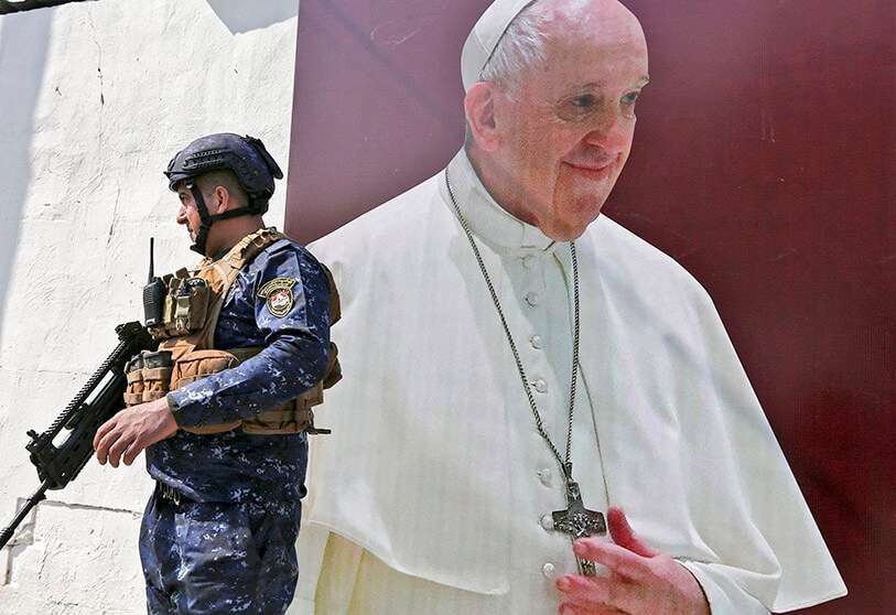 Un miembro de las fuerzas iraquíes junto a un cartel con la imagen del Papa Francisco en la iglesia católica siríaca de Nuestra Señora de la Liberación en el distrito de Karrada AFP/SABAN ARAR