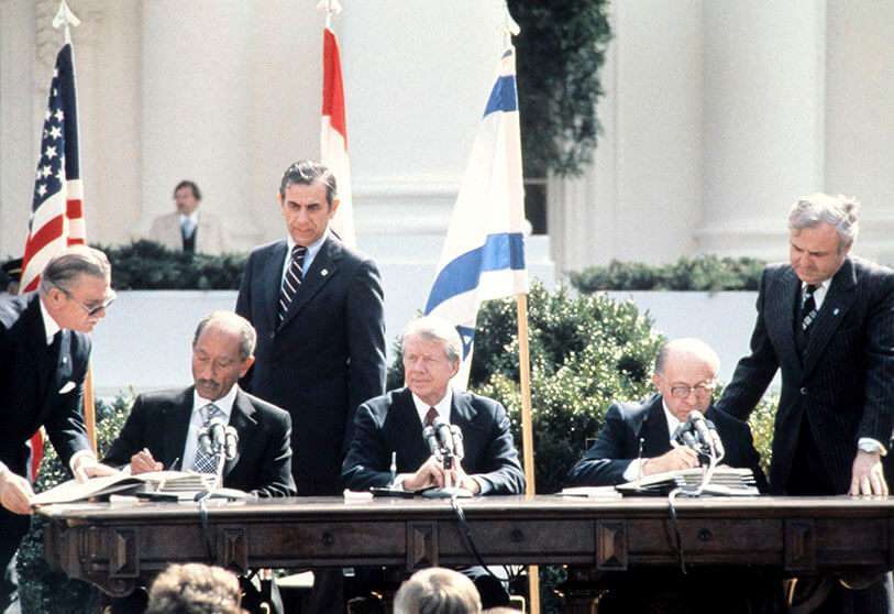 Fotografía de archivo. El presidente egipcio Anwar al-Sadat (izquierda) y el primer ministro israelí Menachem Begin (derecha), entre el presidente de Estados Unidos Jimmy Carter, firman el histórico tratado de paz el 26 de marzo de 1979 en Washington D.C.