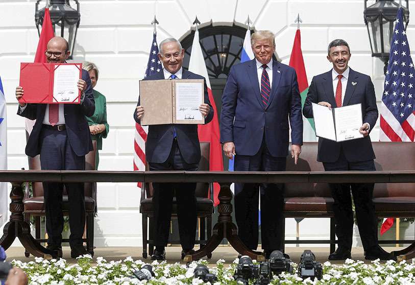 REUTERS/TOM BRENNE - De izquierda a derecha, el ministro de Relaciones Exteriores de Bahréin, Abdullatif al-Zayani, el primer ministro de Israel, Benjamin Netanyahu, y el ministro de Relaciones Exteriores de Emiratos Árabes Unidos (EAU), Abdullah bin Zayed, exhiben sus copias de los acuerdos firmados mientras el presidente de Estados Unidos, Donald Trump, los observa mientras participan en la ceremonia de firma de los Acuerdos de Abraham en Washington