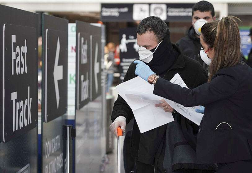 El personal de tierra da información a los pasajeros en el aeropuerto internacional Leonardo da Vinci de Roma, el jueves 12 de marzo de 2020