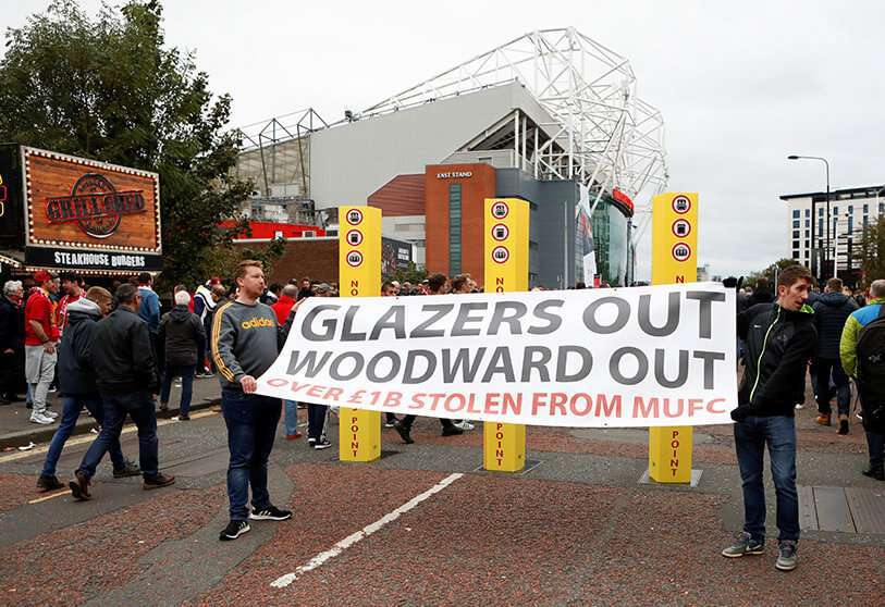 Los aficionados exhiben una pancarta de Glazers y Woodward fuera del estadio