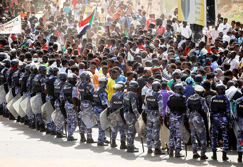 REUTERS/MOHAMED NURELDIN - Agentes de la policía antidisturbios se posicionan contra los manifestantes cerca de los edificios del Parlamento, mientras que miembros de la pro-democracia sudanesa protestan en el aniversario de una gran protesta el 30 de junio de 2020