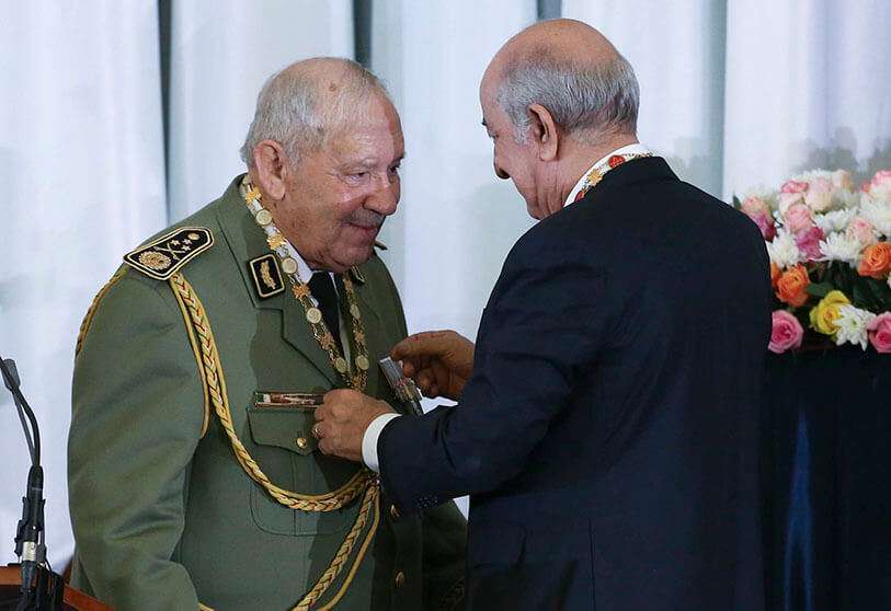 El presidente argelino Abdelmadjid Tebboune (Der) saluda al jefe del Estado Mayor del Ejército argelino, Ahmed Gaïd Salah durante la ceremonia de juramento de Tebboune