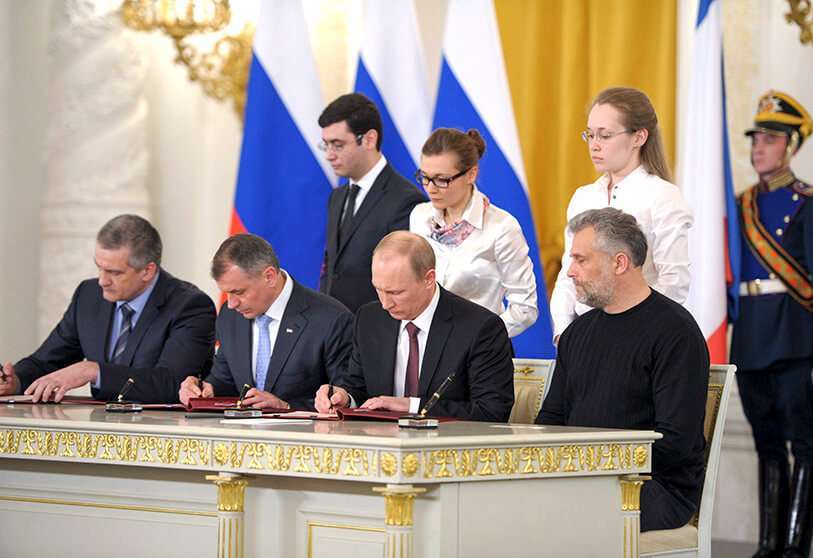 El presidente de Rusia, Vladimir Putin; el primer ministro de Crimea, Sergei Aksyonov, el presidente del Parlamento de Crimea, Vladimir Konstantionov; y Alexei Chaly, el nuevo alcalde de facto de Sebastopol, firman un tratado sobre la península ucraniana del Mar Negro que pasa a formar parte de Rusia en el Kremlin en Moscú el 18 de marzo de 2014
