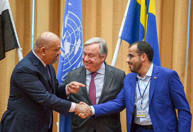 El ministro de Relaciones Exteriores de Yemen, Khaled al-Yamani (izquierda), y el negociador rebelde Mohamed Abdelsalam (derecha) se dan la mano bajo la mirada del secretario general de Naciones Unidas, António Guterres (derecha), durante las consultas de paz de Estocolmo, Suecia, el 13 de diciembre de 2018