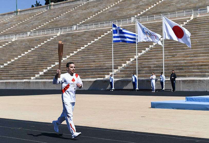 Un atleta lleva la antorcha olímpica durante uno de los últimos relevos antes de la ceremonia de entrega de la llama olímpica para las Olimpiadas de Verano de Tokio de 2020, el 19 de marzo de 2020 en Atenas