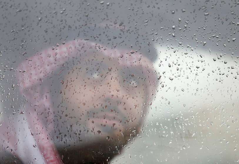 Un hombre saudí mira por una ventana durante la lluvia en Riad, Arabia Saudí