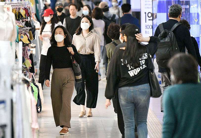 Des personnes portant des masques marchent dans une zone commerciale souterraine à Séoul le 6 mai 2020