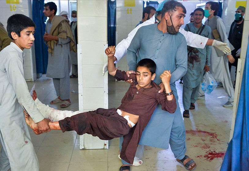 Voluntarios llevan a un niño herido después de un ataque suicida en el funeral de un comandante de la policía local en Nangarhar, el 12 de mayo de 2020