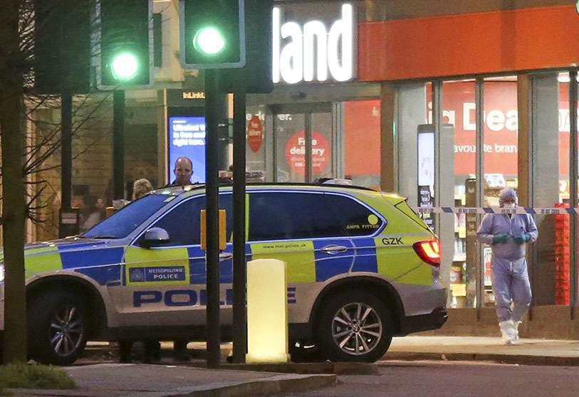 Un oficial forense de la Policía (R) trabaja en Streatham High Road en el sur de Londres el 2 de febrero de 2020, después de que un hombre es asesinado a tiros por la policía tras los informes de personas apuñaladas en la calle