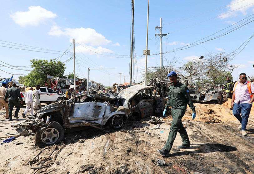 Un oficial de la Policía somalí pasa junto a los restos de un coche bomba en un puesto de control en Mogadiscio, Somalia, el 28 de diciembre de 2019