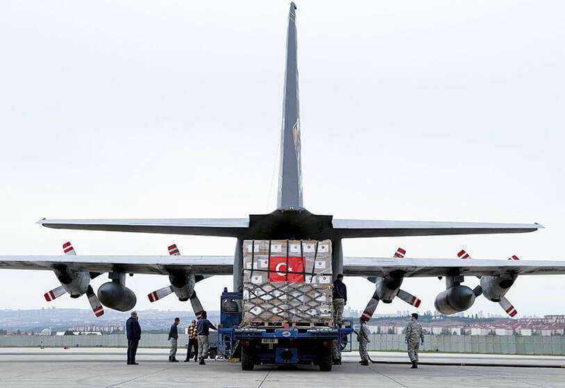 Soldados turcos cargan un avión de carga militar turco con equipo de protección personal donado por Turquía
