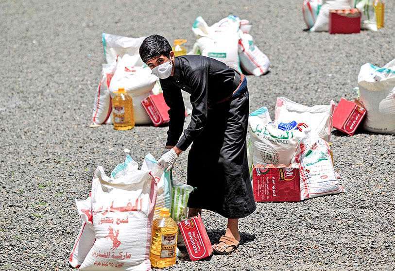 Un joven yemení lleva ayuda alimentaria distribuida por la fundación de desarrollo Yadon Tabney, en Sanaa, el 17 de mayo de 2020