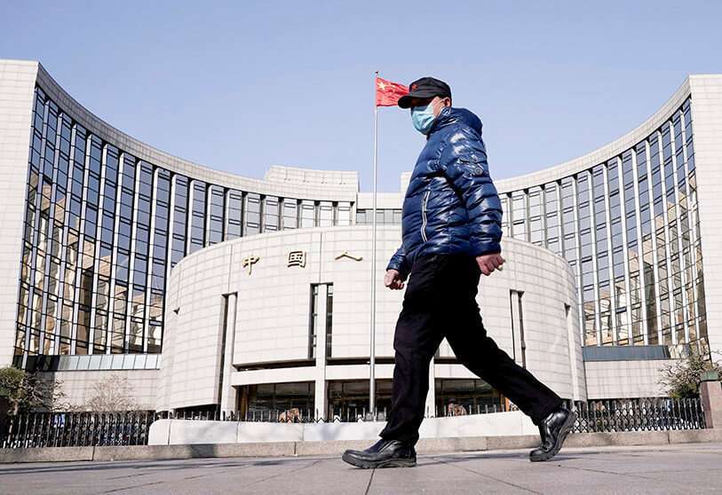 Un hombre con una máscara pasa por delante de la sede del Banco Popular de China, el banco central, en Pekín, China PHOTO/REUTERS