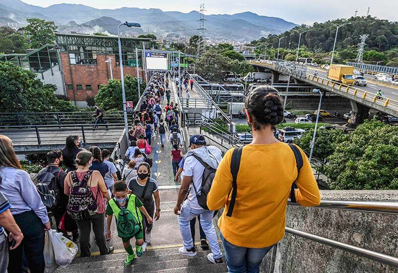La gente hace cola en un puente mientras viaja cerca de una estación de metro de camino a casa antes de un toque de queda, en medio de la pandemia de COVID 19 en Medellín, Colombia, el 31 de marzo de 2021 AFP/ JOAQUIN SARMIENTO